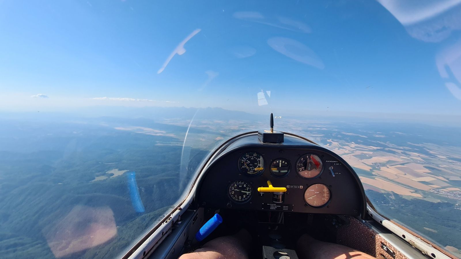 Kabína vetroňa nad lesmi, na obzore Vysoké Tatry