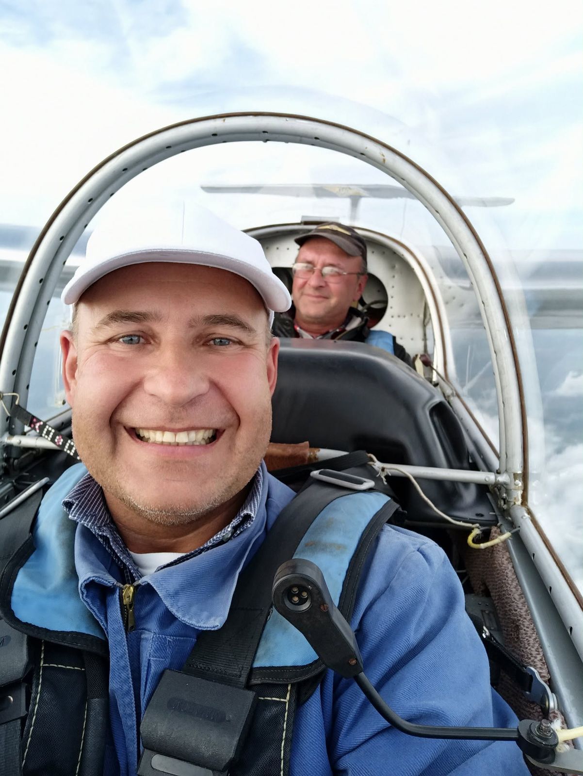 Usmiaty pilot a inštruktor v kabíne vetroňa počas letu