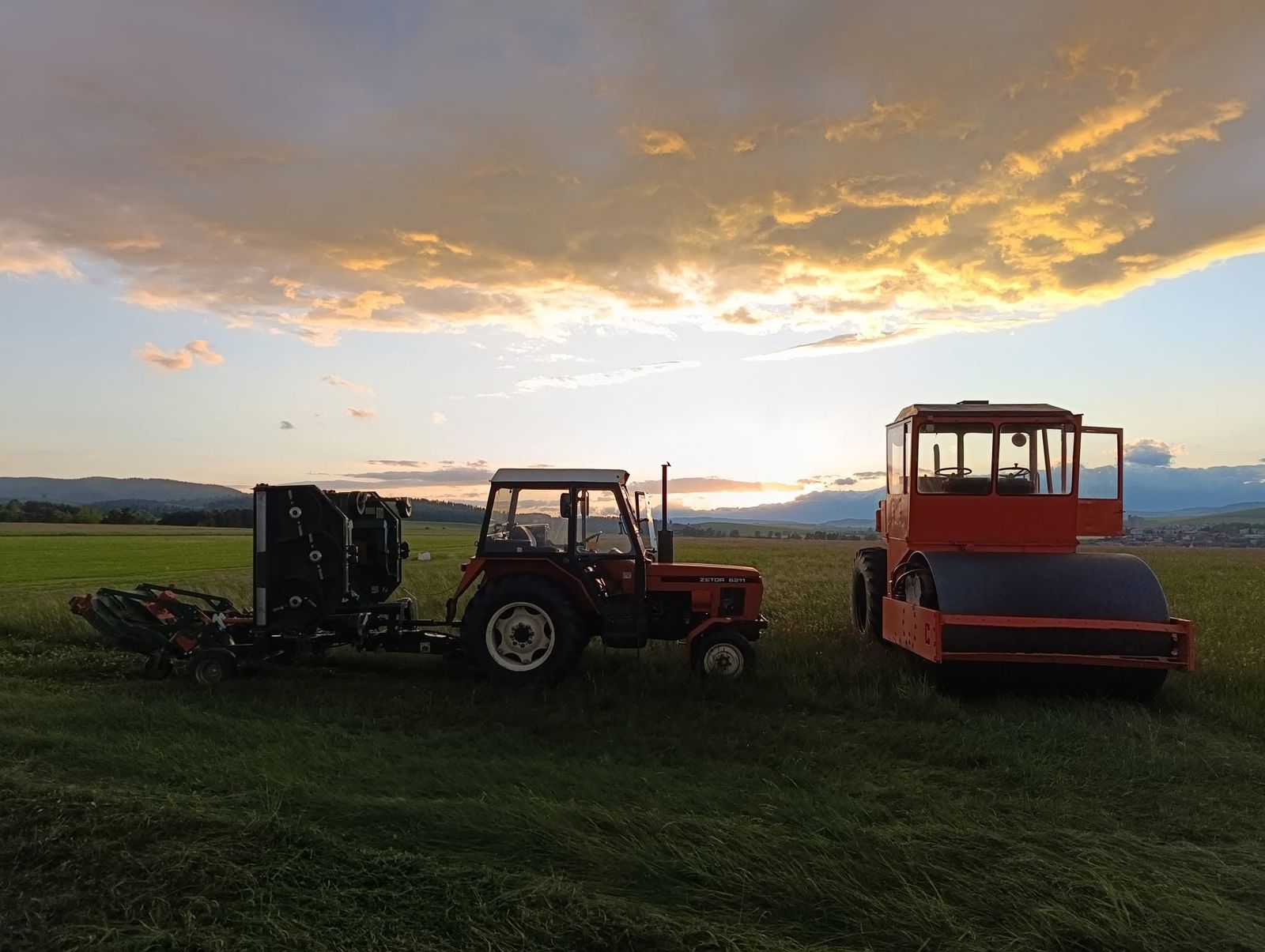 Traktor Zetor a cestný valec na letisku pri západe slnka