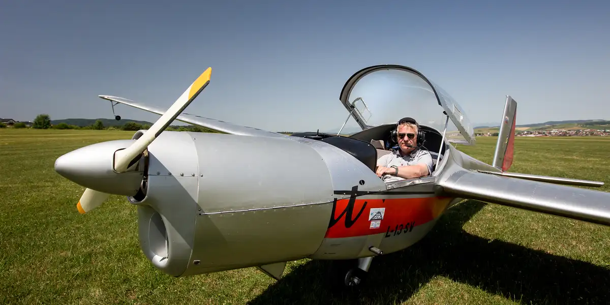 Motorový klzák L-13 SE Vivat s pilotom v kabíne na letisku